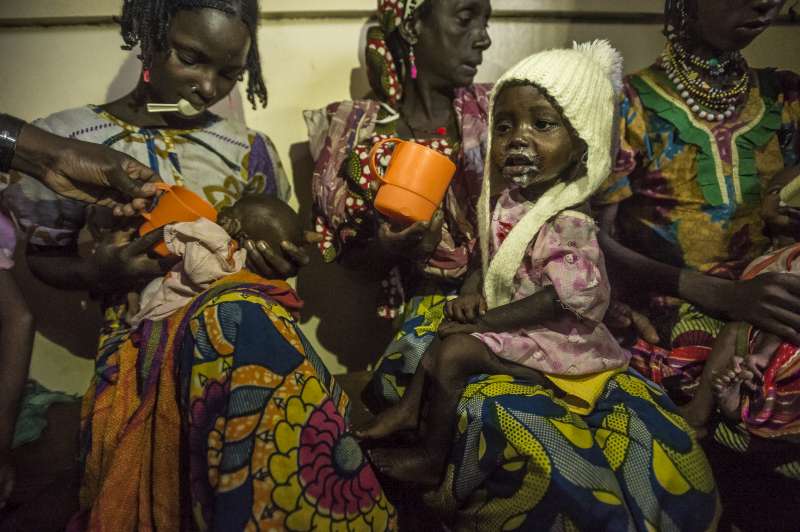 أطفال يعانون من سوء التغذية من جمهورية إفريقيا الوسطى مع أمهاتهم في مستشفى باتوري خلال جلسة غذائية. يعاني العديد من الأطفال الذين يعبرون الحدود إلى الكاميرون من سوء التغذية.