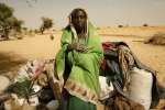 A newly arrived refugee from the Darfur region of Sudan rests next to her belongings in Seneit, Birak area, eastern Chad. 