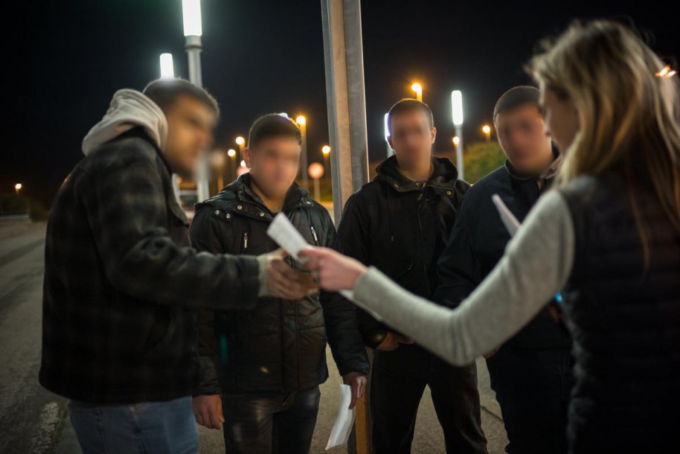 A volunteer from the charity Citizens UK in Calais hands Ahmed, Khalil, Abdul and Mohammad their Eurostar tickets to London.