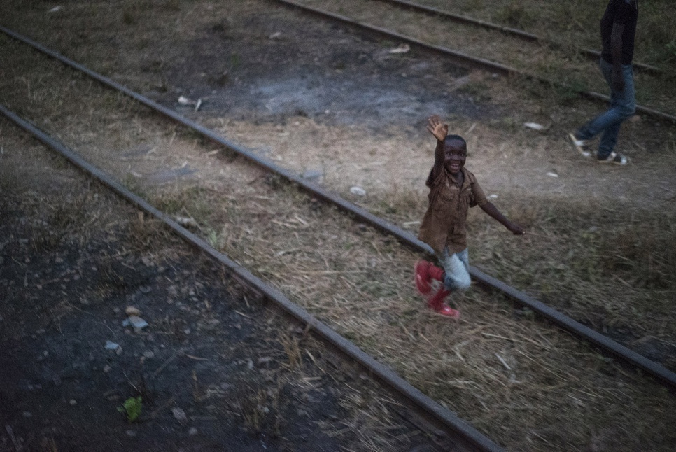 A Congolese boy waves at a train carrying hundreds of former refugees home to Angola. The journey will take about 36 hours.