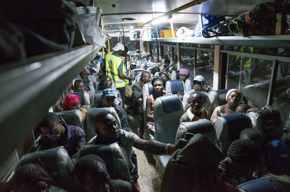 After having their documents verified by Angolan authorities, former refugees wait on a bus before leaving Kimpangu, DRC, for the nearby Angolan border.