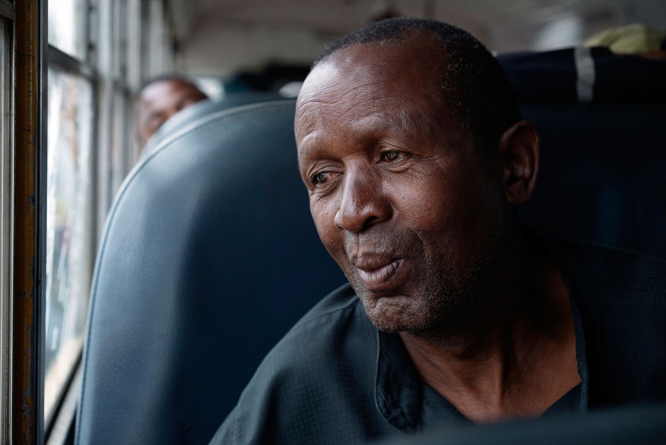 Theophile, 66, sits aboard a bus on his way home to Angola. After decades in exile, he has mixed feelings about leaving the community that gave him refuge.