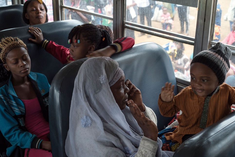 Flore Linda, 34, plays with her two-year-old son aboard a bus headed for Angola. Both mother and child were born in exile and will be seeing their homeland for the first time.