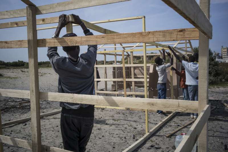 Sudanese refugees build a shelter, with the help of Julien Bélart, a 22 year-old volunteer from Calais, who provides pieces of wood, tools, and other materials. He used his school grant to help refugees.