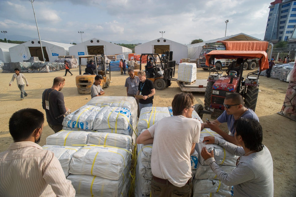 Aid workers from UNHCR and local partners, including volunteers from Yellow House, unload plastic tarps at the airport in Kathmandu, Nepal.