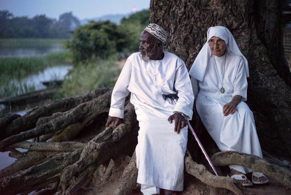 Imam Moussa Bawa, 72, and Sister Maria Concetta, 80, discuss their hopes for the future on the banks of the Oubangui river in Zongo, Equateur Province, DRC."