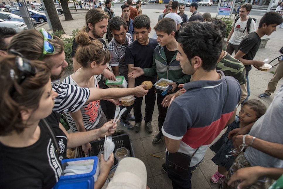It is dusk by the time volunteers arrive at a busy square in Budapest. The food they carry is a lifeline for the tired and hungry refugees who are there to meet them.
