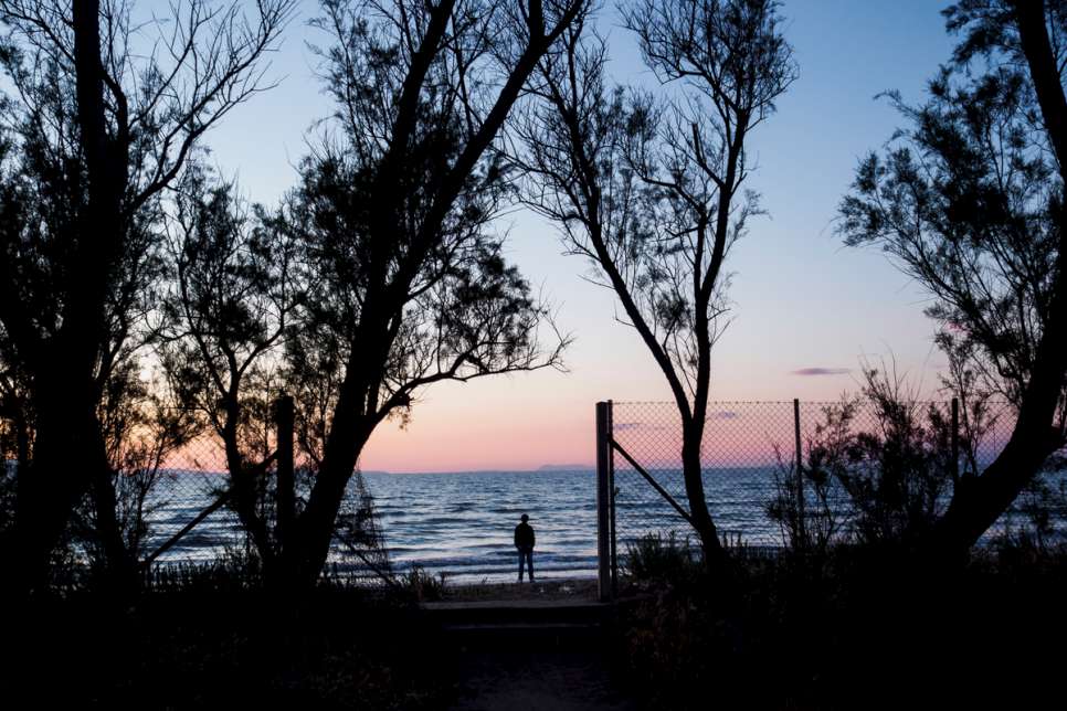 A young boy from Syria watches the sunset from the beach at LM Village.