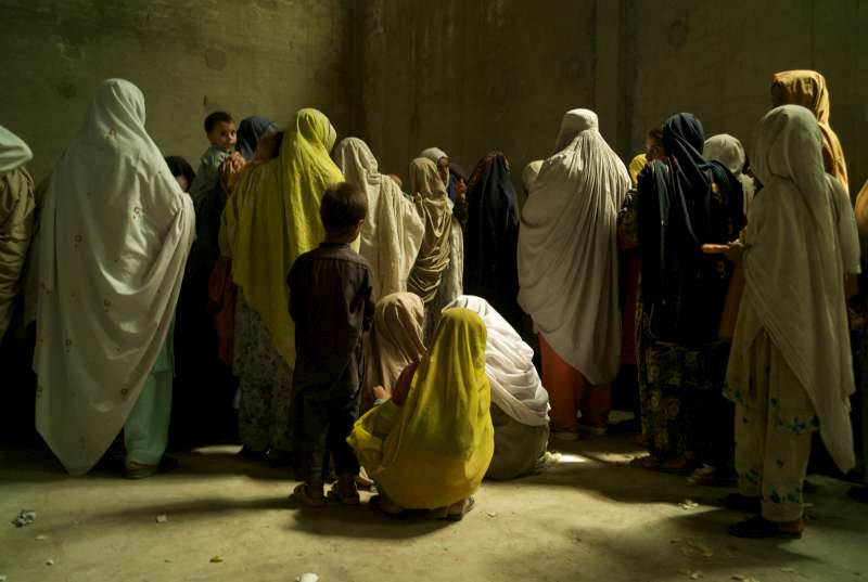KATLANG, PAKISTAN- MAI 2009
Une foule de femmes et d'enfants récemment arrivés qui ont fui les conflits à Swat et à Buner attendent pour montrer leurs cartes de réfugiés temporaires lors d'une distribution de riz et d'huile dans une vieille usine de cigarettes près de Mardan.
