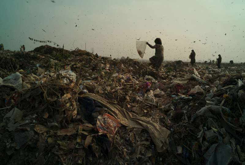 LAHORE, PAKISTAN- NOVEMBRE 2009 
Une jeune fille afghane portant un sac se fraie un chemin à travers les ordures fraîchement déversées dans la décharge de la ville de Lahore. Commençant à travailler à tout juste quatre ans, les enfants cherchent du plastique, du verre, du papier, du bois, du cuir et du tissu qui seront ensuite triés et recyclés par leurs familles pour gagner de l'argent. 
