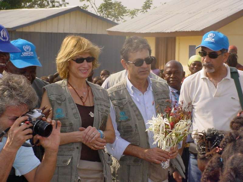 Goodwill Ambassador George Dalaras (with flowers), his wife Anna and UNHCR staff at a welcoming ceremony in a Sierra Leone refugee camp.