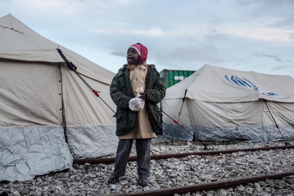 A refugee girl from South Sudan eats a snack in the transit center for refugees and migrants in Idomeni, Greece.