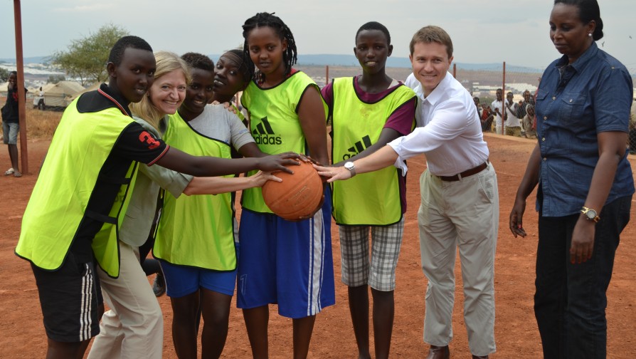 US envoy to Rwanda, Erica J. Barks-Ruggle, and British High Commissioner to Rwanda, William Gelling pose for a baksetball team group photo with refugees at the camp [Photo/ UNHCR - Eugene Sibomana]