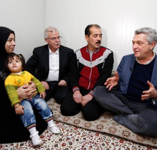 Syrian mother Fatma and her daughter Farah, sit with Gaziantep province Deputy Governor Halil Uyumaz, Fatma's husband Ahmed and UN High Commissioner for Refugees Filippo Grandi at Nizip II refugee camp.