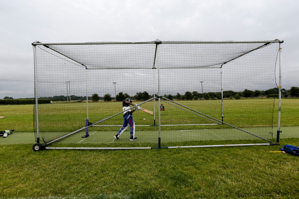 Un réfugié rohingya s'exerce au lancer dans les cages du club de cricket de Carlow. 