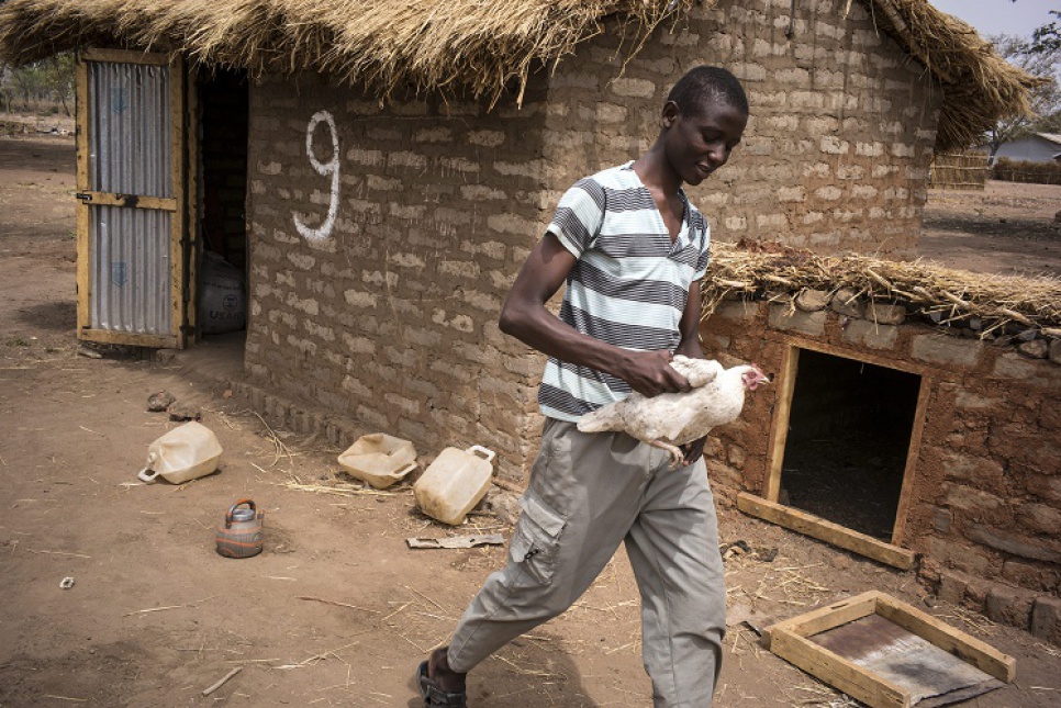 Adim, 16, looks for chicken eggs in front of his house in Dosseye camp. The boys' monthly food rations often run low after 20 days, leaving them to rely on the generosity of neighbours.