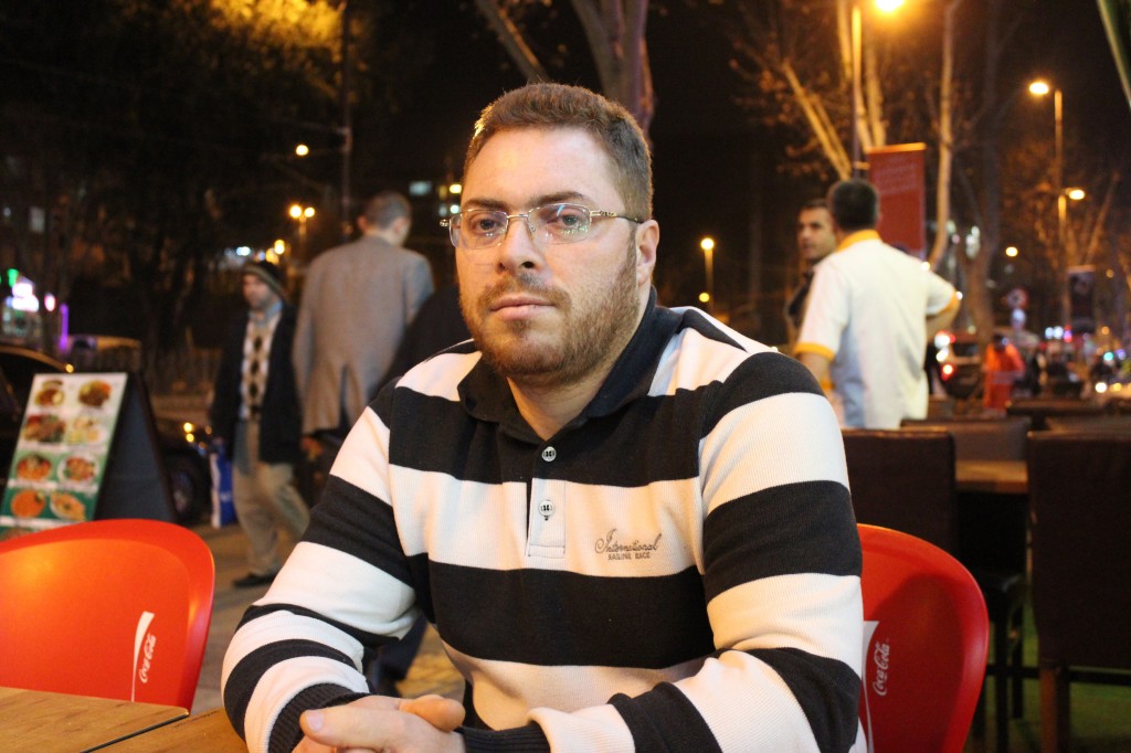 Abdullah is sitting outside of the bakery he co-owns in Istanbul.  E. Feldman, January, 2014