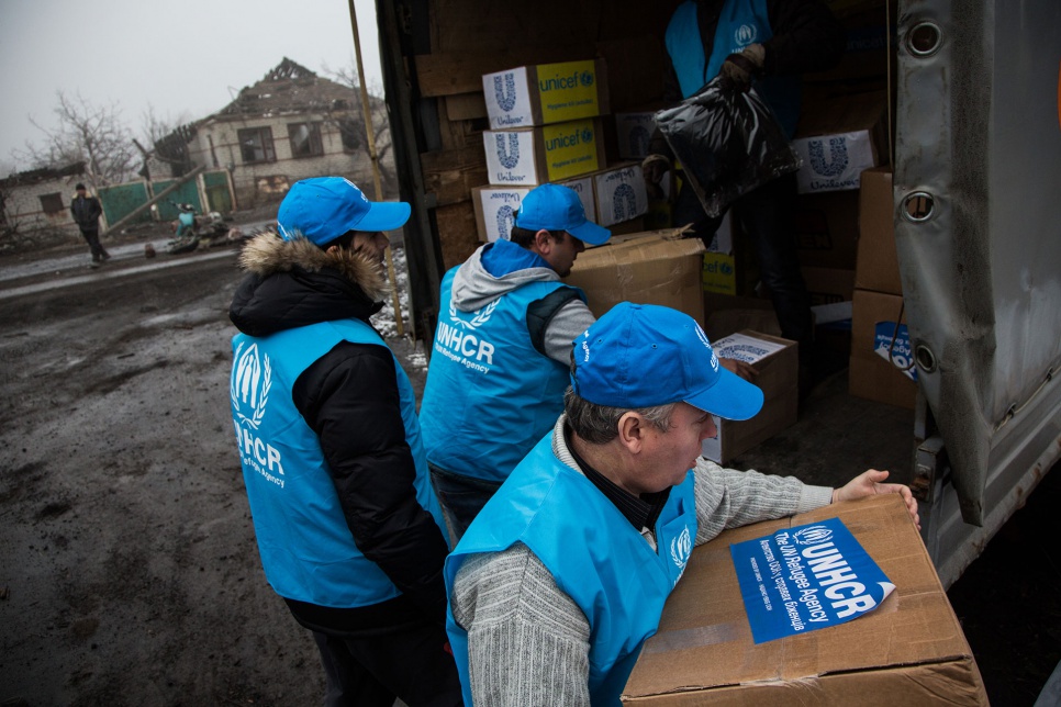 UNHCR field workers unload food, blankets, clothes and hygiene kits for residents of Nikishino, Ukraine, made homeless by the destruction.