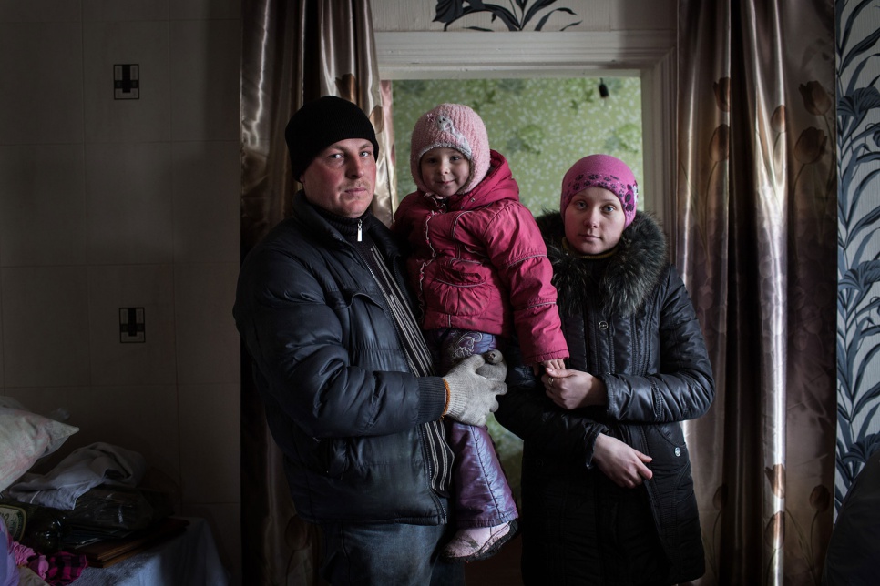 Sergei, Katia and daughter Sofia, 3, return home after receiving aid from UNHCR in Nikishino, in eastern Ukraine. Fighting has displaced over 1 million people inside Ukraine.