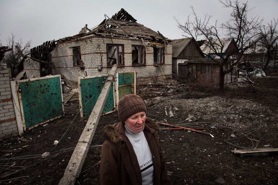 Liuba stands in front of her destroyed home in Nikishino, Ukraine. After searching for her children's clothes inside, she climbed out the front window to avoid unexploded ordnance. "When it gets warm we return to live," said Liuba defiantly. "We will start with one room."
