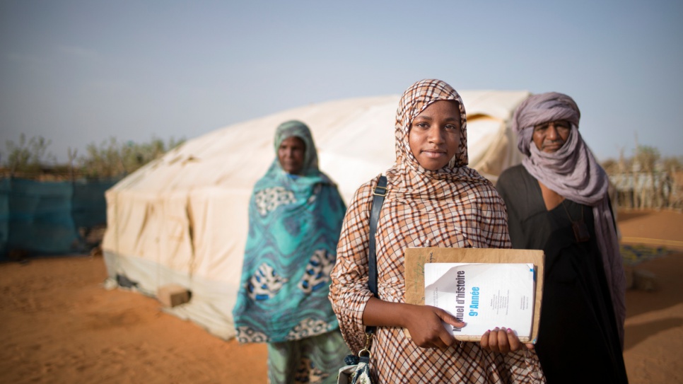 Malian refugee Tinalbarka, 16, with her parents as she leaves the family tent to attend classes at secondary school in Mbera refugee camp in Mauritania.