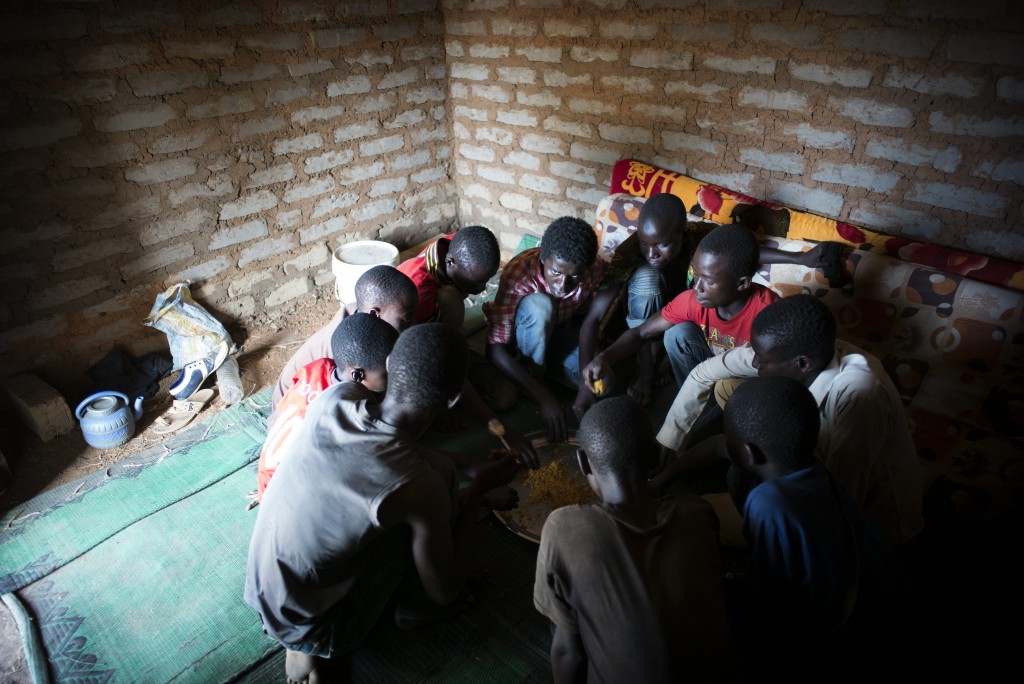 Most of the 12 refugee boys eat lunch in a shelter at Dosseye camp in southern Chad. When food supplies are running low, the boys only manage two meals a day.