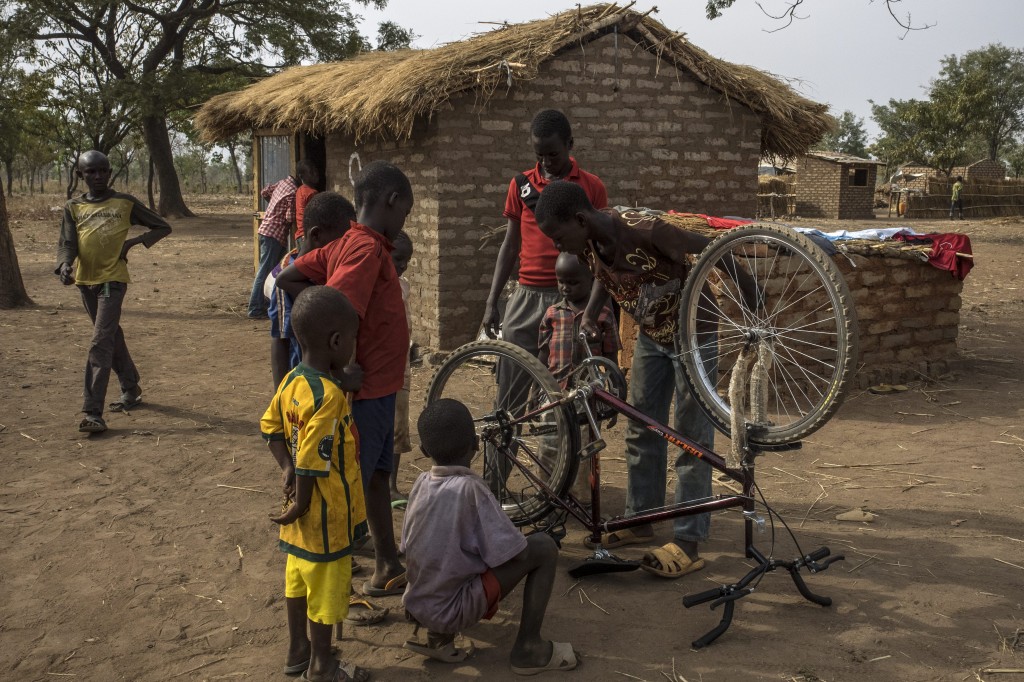 Moustapha, 15, tries to repair his bike, which was provided by UNHCR. The boys use their bikes to ride seven kilometres to school.