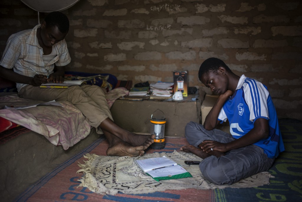 Bachir (left) , 17, and Mahamat, 15, complete homework in their shelter in Dosseye refugee camp in Chad. 