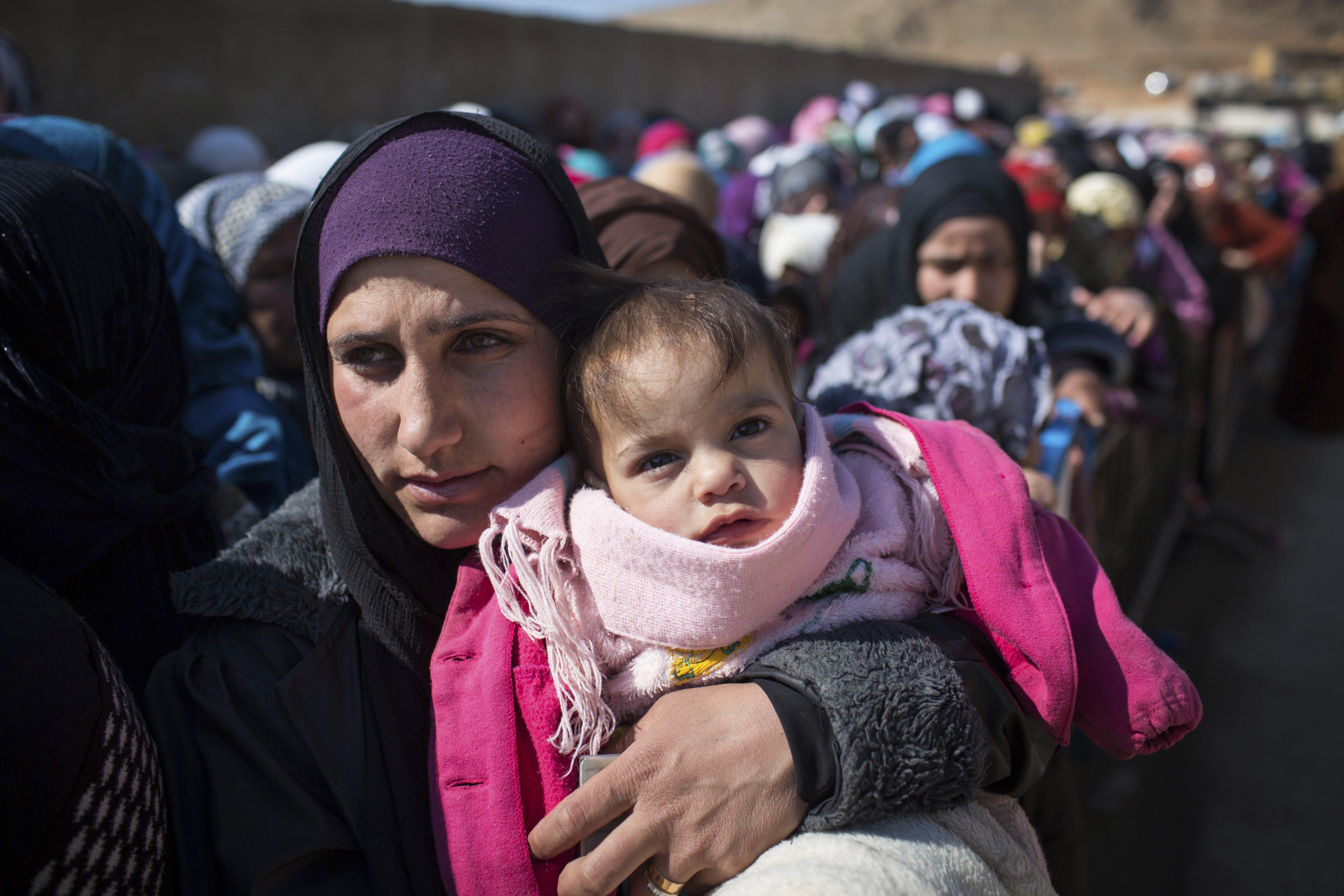 Newly arrived Syrian refugee women and children queue for registration and aid distribution in the town of Arsal, Lebanon, on 17 February 2014.