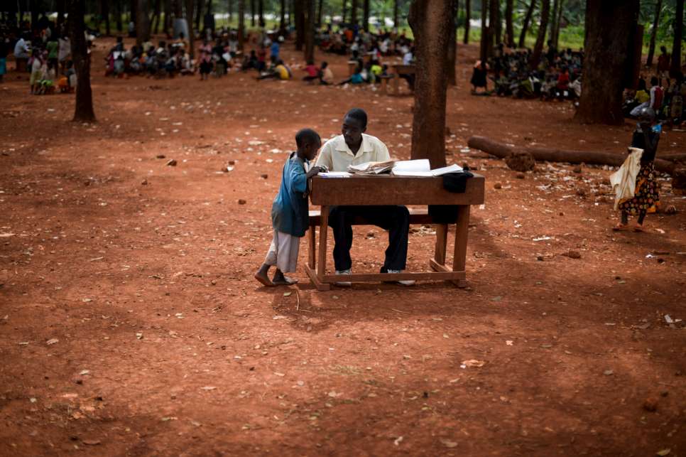 Children attend school outdoors because there are not enough classrooms for 10,000 of them and only 103 teachers. When it rains, children return to their tents.