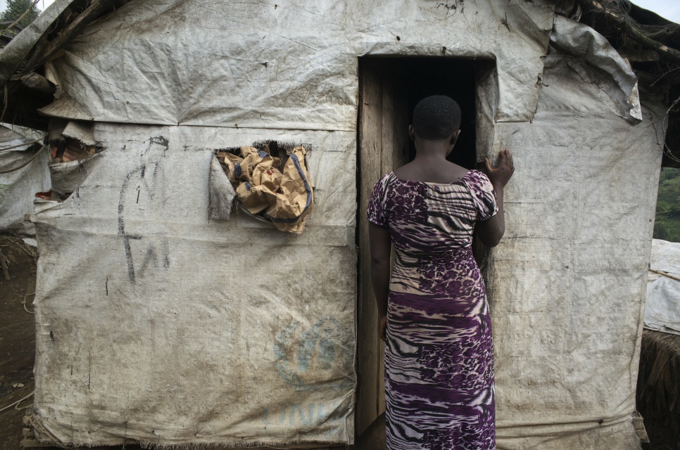 "Juliette" stands at the entrance of her shelter in Lushebere camp. As a leader of the sex workers' group, she organizes talks about gender violence and sexually transmitted diseases.