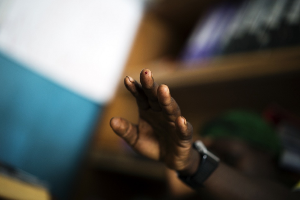 A woman has blood drawn from her finger for an STD test at the health center in Kitsule, North Kivu. HIV and syphilis tests are able to give results within three minutes.