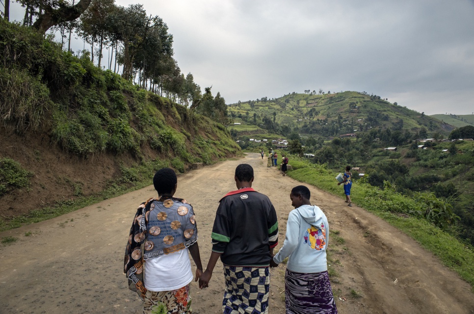 "Juliette," right, and two other sex workers walk up the road from Lushebere camp to the health centre in Kitsule, North Kivu.