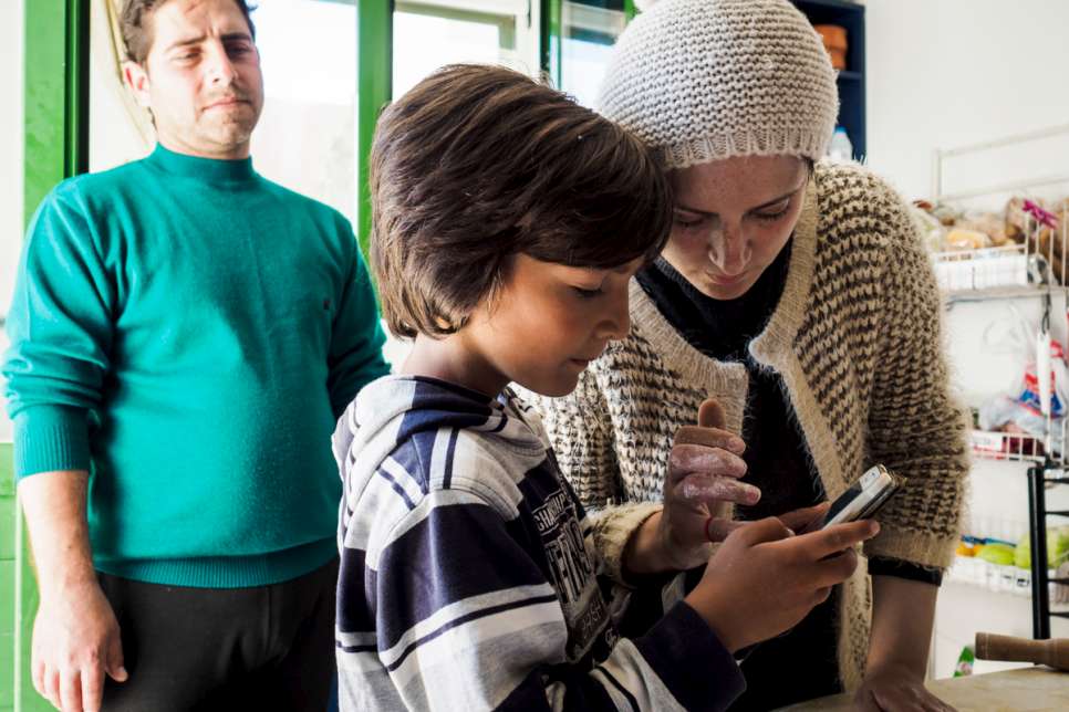 Kindra and her son check their cell phone for calls from the asylum service.