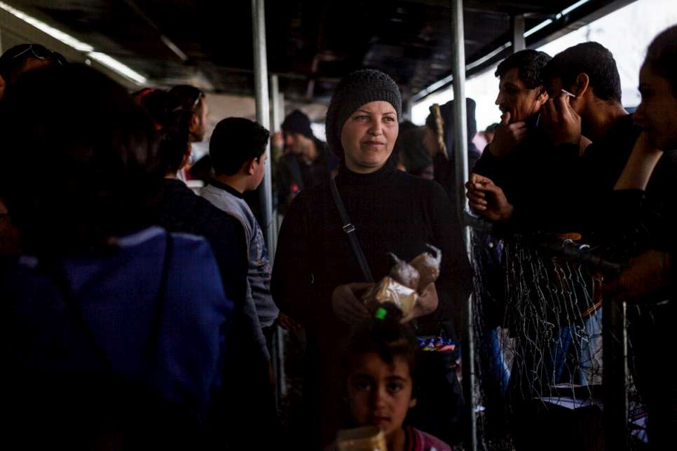 Nisrine stands in a queue to receive food for her children at the Idomeni transit camp, where more than 12,000 people now face an uncertain future.