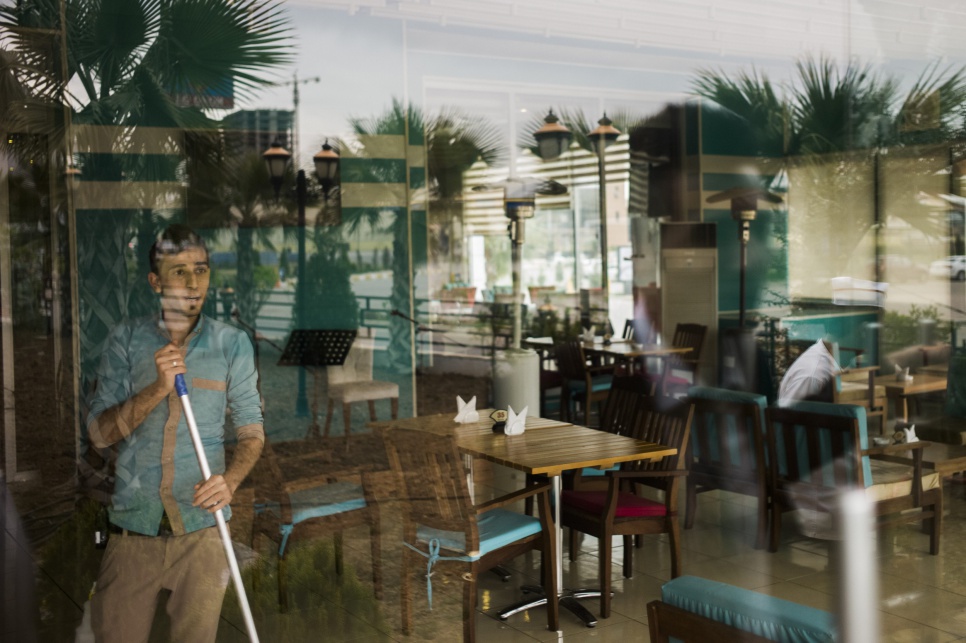 A Syrian refugee gazes out onto the streets of Erbil, in the Kurdistan Region of Iraq, where he works in a hotel restaurant.