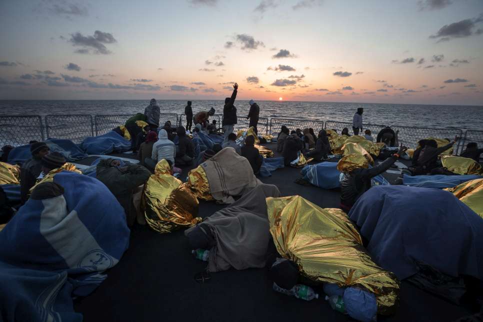 During one Mare Nostrum rescue operation, 220 people – from Nigeria, Pakistan, Nepal, Ethiopia, Sudan, Malaysia and Syria – huddle under blankets on the deck of an Italian Navy ship, waiting to be transferred to the mainland. 