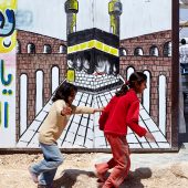 Photo of a caravan and two young refugees in Za'atari camp.