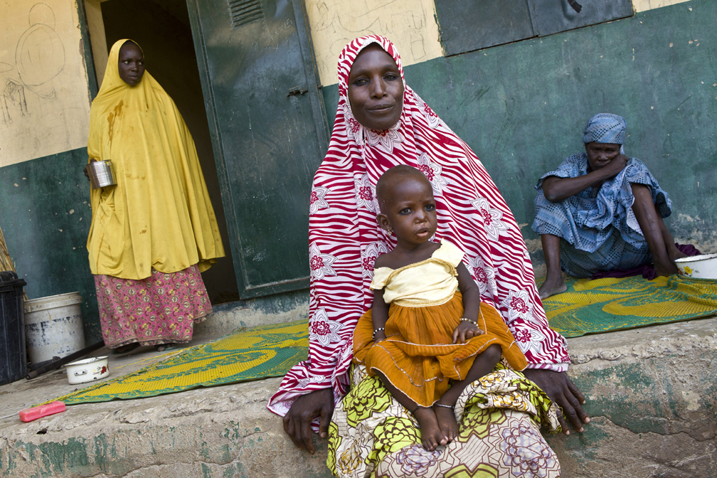 Falmata, 32, rests with her daughter Mamagona in Kuya camp, in Mongouno, north-east Nigeria. The sixteen-month-old girl suffers from malnutrition and is being treated at a small nearby clinic run by the non-governmental organization Halima. "Boko Haram attacked my village, in Marte local government, six weeks ago, they stole all of our belongings and our food" explains Falmata. "I walked for two days before reaching Mongouno, with Mamagona on my back, while my other daughter, who is five, was by my side. Most people from my village fled and are in Mongouno now, many are in Kuya camp with me. Mamagona's health started to deteriorate when we were in the camp, there is not enough food here, I don't have enough millet to give to her. The clinic at Halima gives her a Plum Peanut treatement but she does not like it, it makes her vomit. I don't want to go back to my village at this point, it is too dangerous with Boko Haram in the area. I am alone with the girls, my husband left some weeks ago, he was fearing for his life because of the insurgents. I don't know  where he is, I have no news  " © UNHCR / Helene Caux