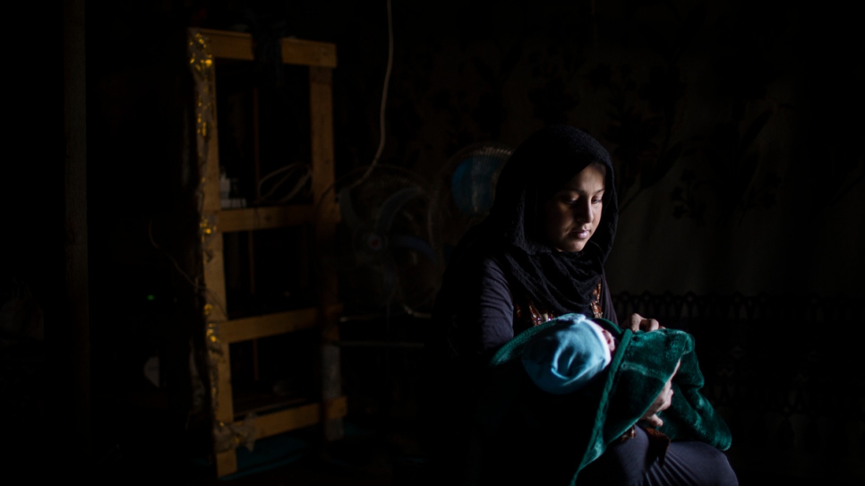 Syrian refugee Muna, 19, holds her newborn son Mahmood, at her temporary shelter in the informal settlement of Tal Sarhoun, Bekaa Valley, Lebanon.
