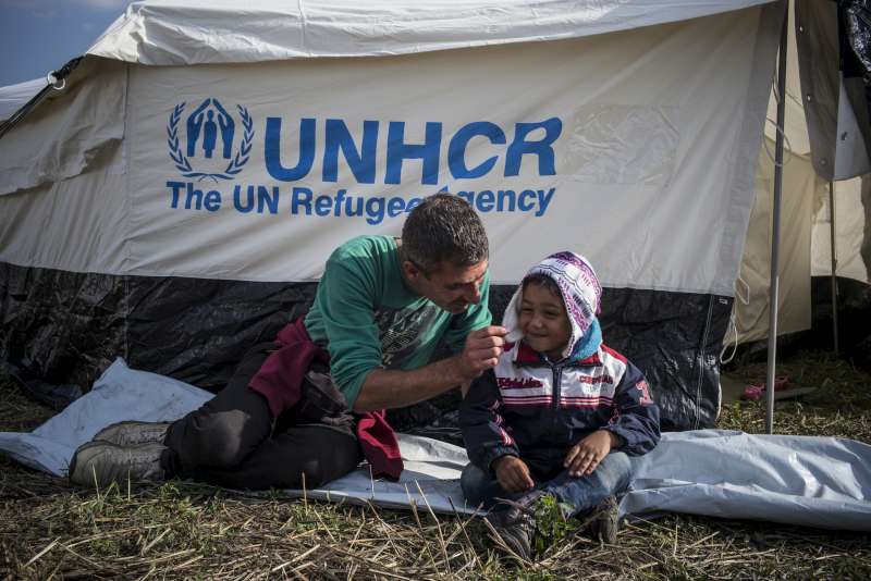 Mahmoud, un réfugié syrien d'Alep, joue avec Jawad, son fils âgé de 4 ans, devant leur tente en Hongrie. 