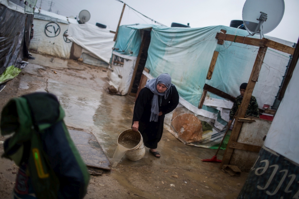 La réfugiée syrienne Fatima vide les eaux usées hors de son abri dans une installation informelle située à la périphérie de Zahle, dans la plaine de la Bekaa.