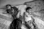  طفلان سوريان لاجئان ينامان على مرتبة في غرفة المعيشة بإحدى الشقق الصغيرة في حي مساكن عثمان الفقير بمدينة السادس من أكتوبر. ويفضل العديد من السوريين في هذه المنطقة البقاء في منازلهم.