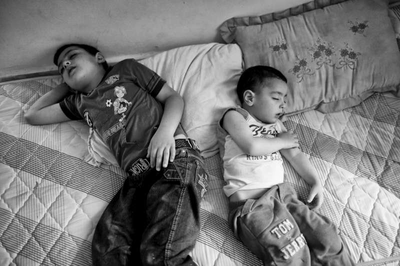  طفلان سوريان لاجئان ينامان على مرتبة في غرفة المعيشة بإحدى الشقق الصغيرة في حي مساكن عثمان الفقير بمدينة السادس من أكتوبر. ويفضل العديد من السوريين في هذه المنطقة البقاء في منازلهم.