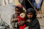 Internally displaced Yemeni sisters Dalal, four, and Radha, three, cli...