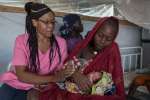 A forcibly displaced mother holds her newborn child at the maternity u...