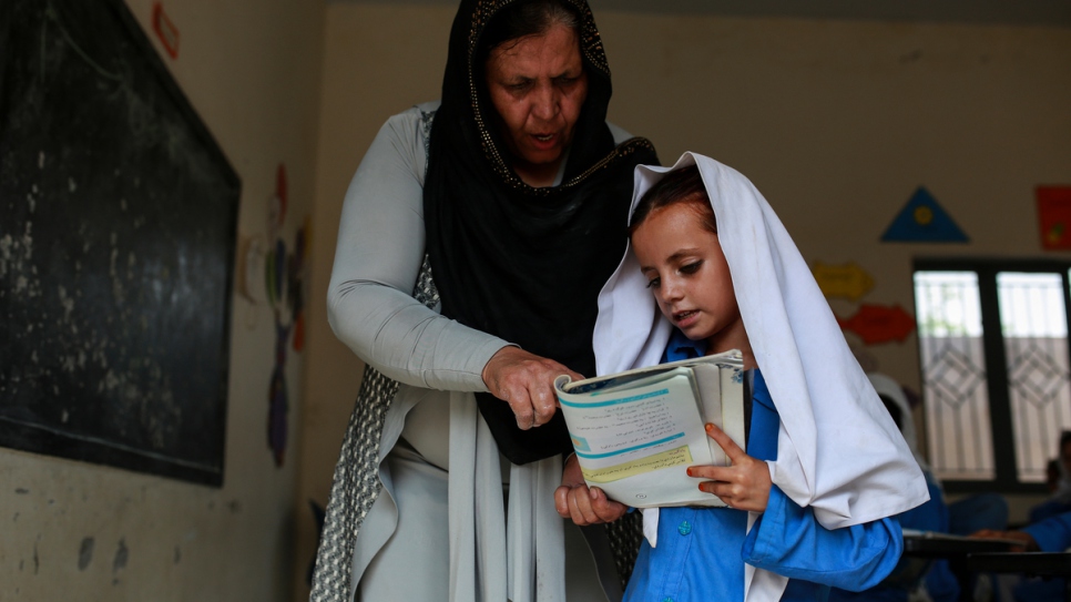 Aqeela Asifi helps one of her young students. The 2015 Nansen Award winner started this school in 1992 with a borrowed tent and handwritten texts.