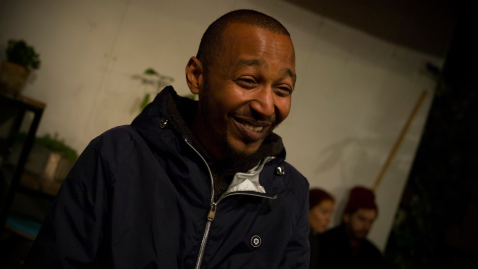 Mussa Idris, who is from Eritrea but now has legal protection in Hungary, laughs while talking with volunteers at the Auróra cultural center in Budapest.