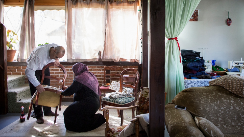 Toufic and Rabiaa work together to reupholster a chair.