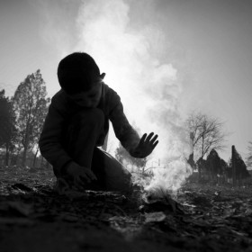 Un niño sirio intenta comenzar una fogata un frío día invernal en el Centro de Recepción Refugiados Harmanli. 12 de diciembre, 2013. Foto: Dobrin Kashavelov.